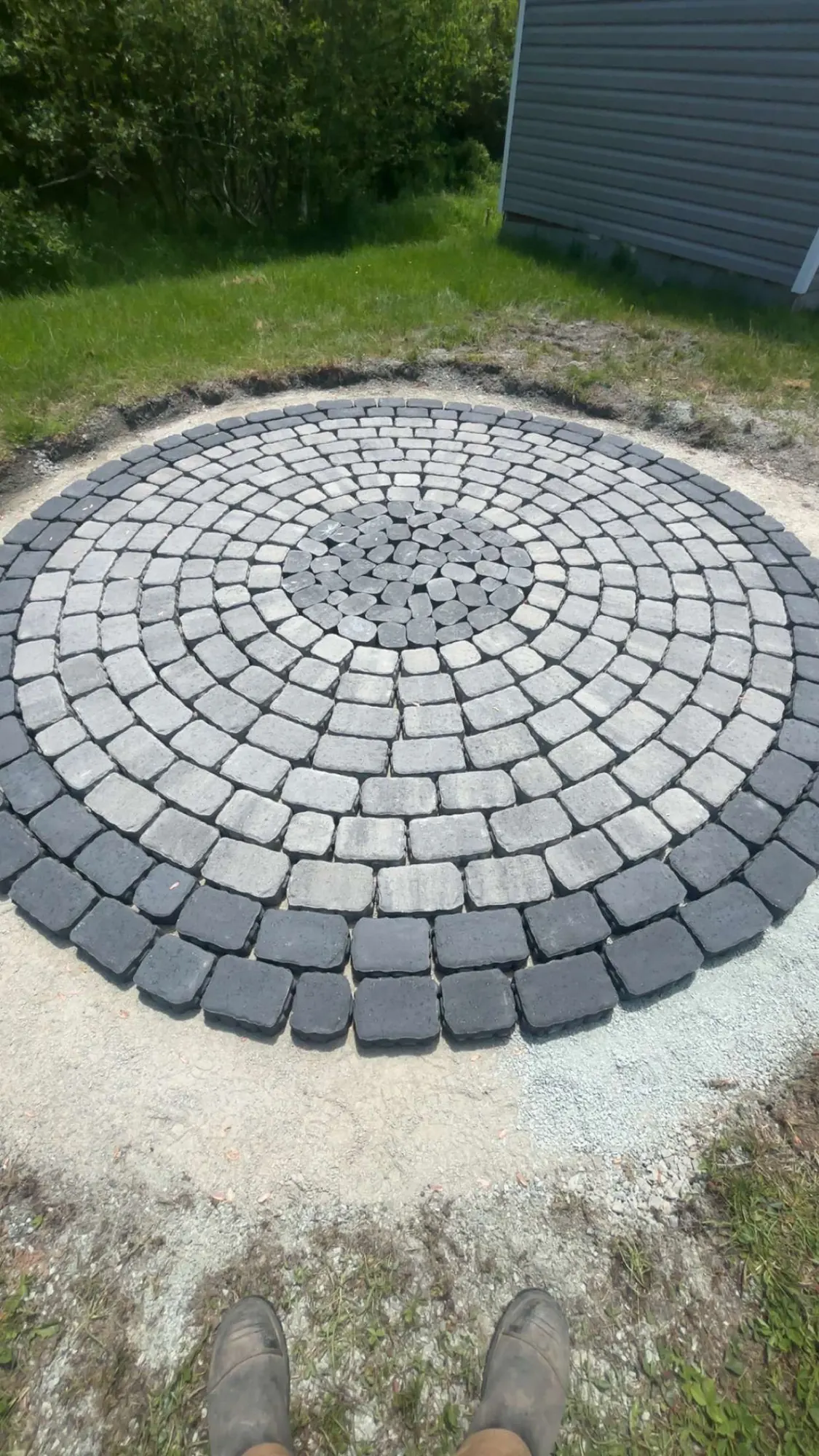 Circular interlocking paver patio in grey and charcoal laid in a fresh sand base