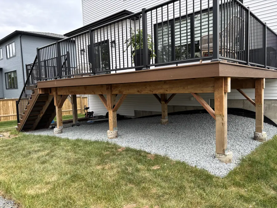 Elevated cedar deck with black railings over a clean gravel base and fresh lawn — hardscaping project in Halifax, Nova Scotia