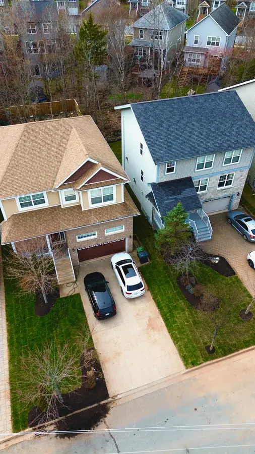Drone view of two homes with landscaped front yards and driveways in a Halifax-area neighbourhood — aerial drone view in the Halifax Regional Municipality, Nova Scotia